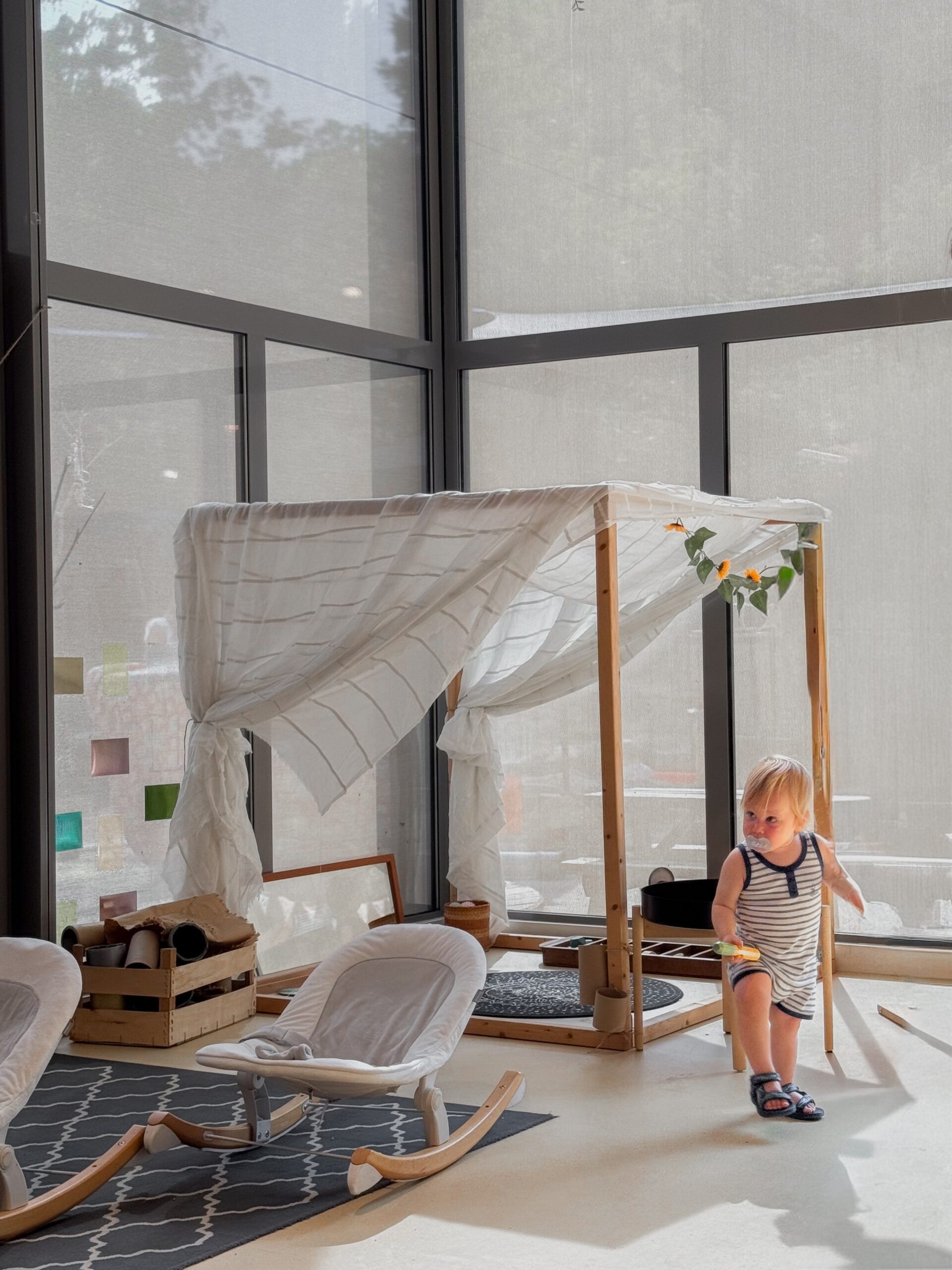 Lichte babygroep met hemelbed en wipstoeltjes waar een peuter speelt bij Best 4 Kids Binnenstad Heerlen