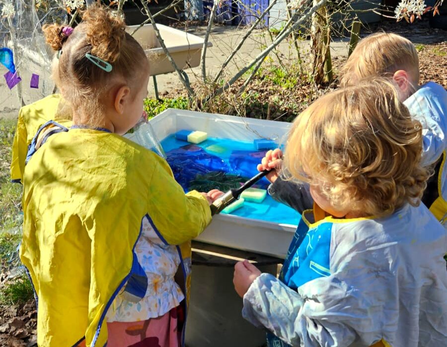 Peuters spelen met water in de buitenruimte van Best 4 Kids De Hoeve in het voorjaar