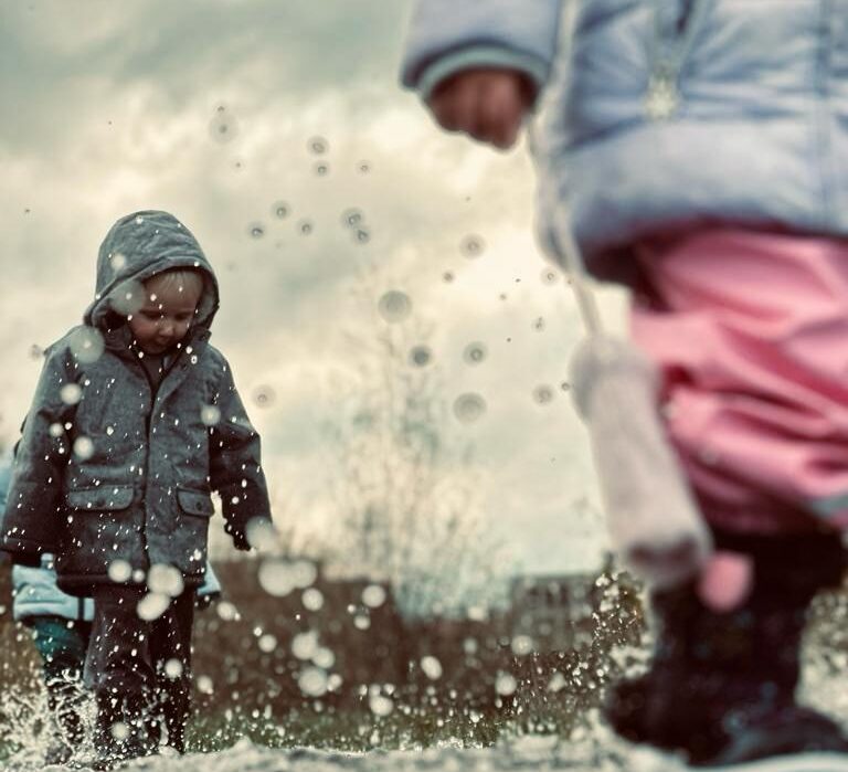 Kinderen spelen buiten in de regen en plassen, geen schermtijd